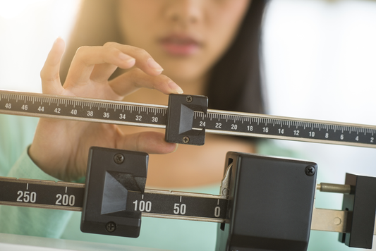woman weighing herself on a scale