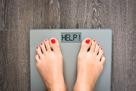 woman's feet on a scale that reads "Help!"