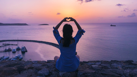 Happy healthy woman meditating on the beach