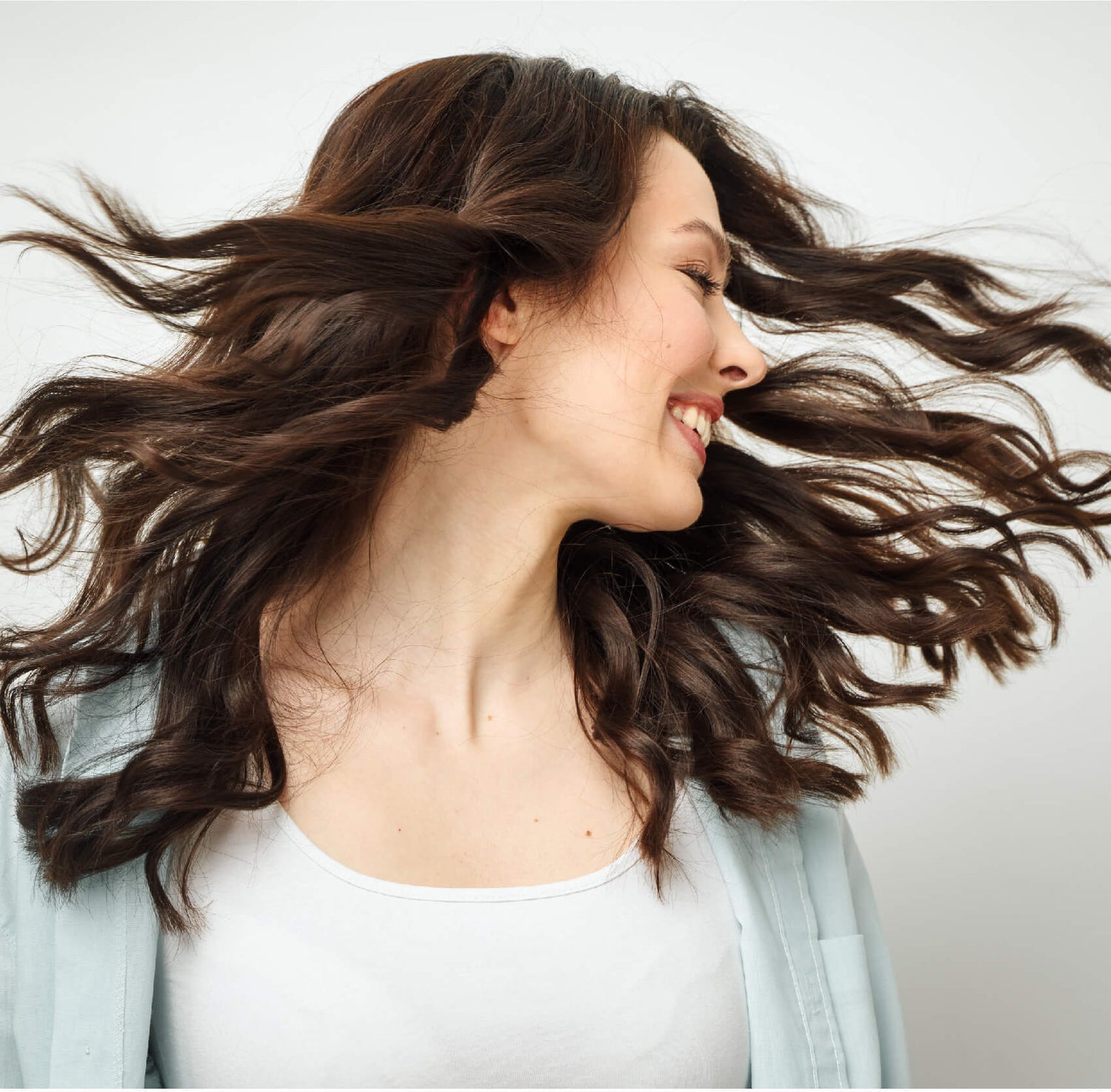 Woman with brown hair flowing as she turns her head