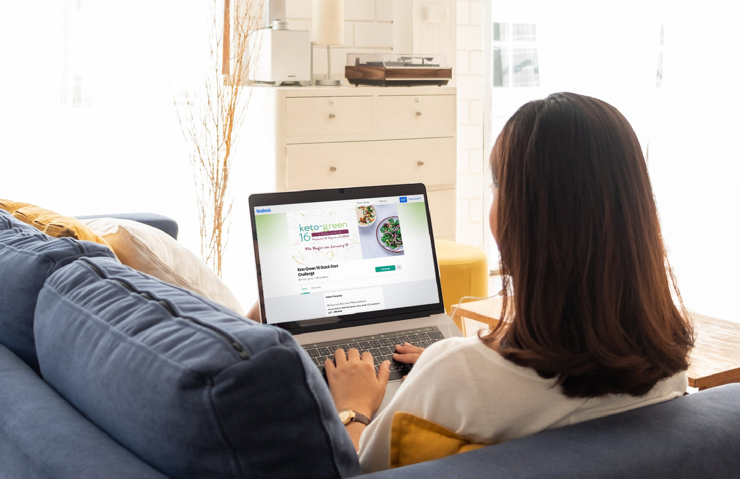 Woman using a laptop which is displaying the Keto-Green Challenge Facebook Group