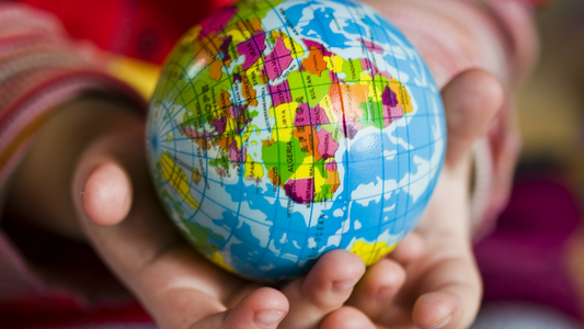 Child's hands holding a planet earth globe