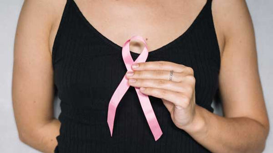 Woman holding up a pink ribbon for breast cancer