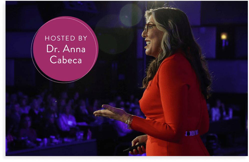 Dr. Anna Cabeca in red speaking on stage 
