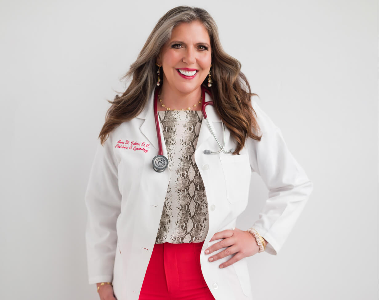 Dr. Cabeca in a white medical coat with a stethoscope, wearing a snake print top and red pants on a white background