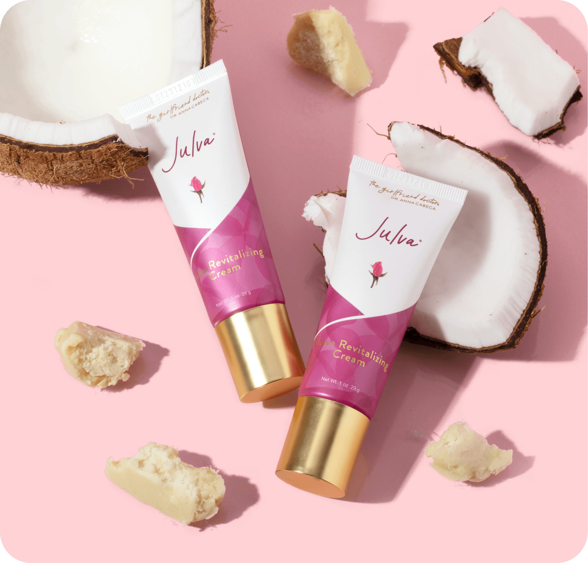 Two tubes of Julva Revitalizing Cream on a pink background with coconut pieces.