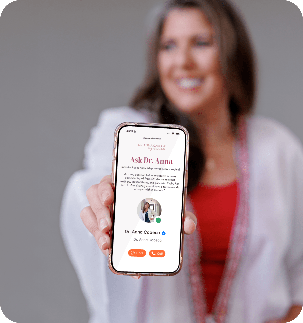 Dr. Anna Cabeca in a white lab coat holds up a smartphone showing a digital profile page for Dr. Anna Cabece, with a blurred background of the same woman smiling.