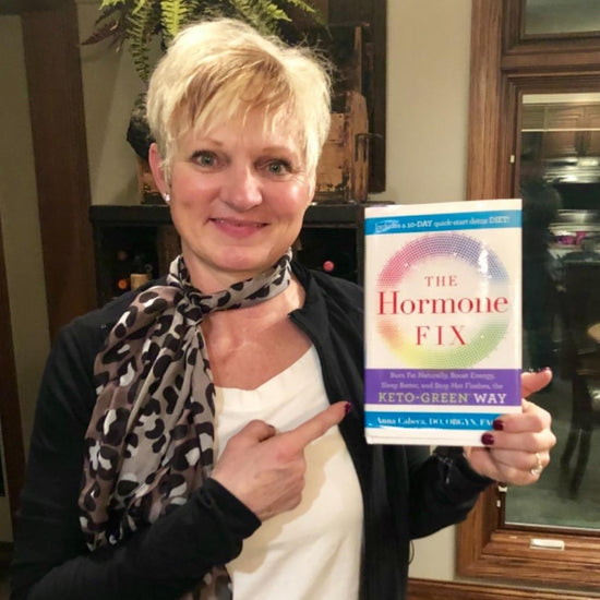 Woman pointing at the Hormone Fix Book, which she's holding